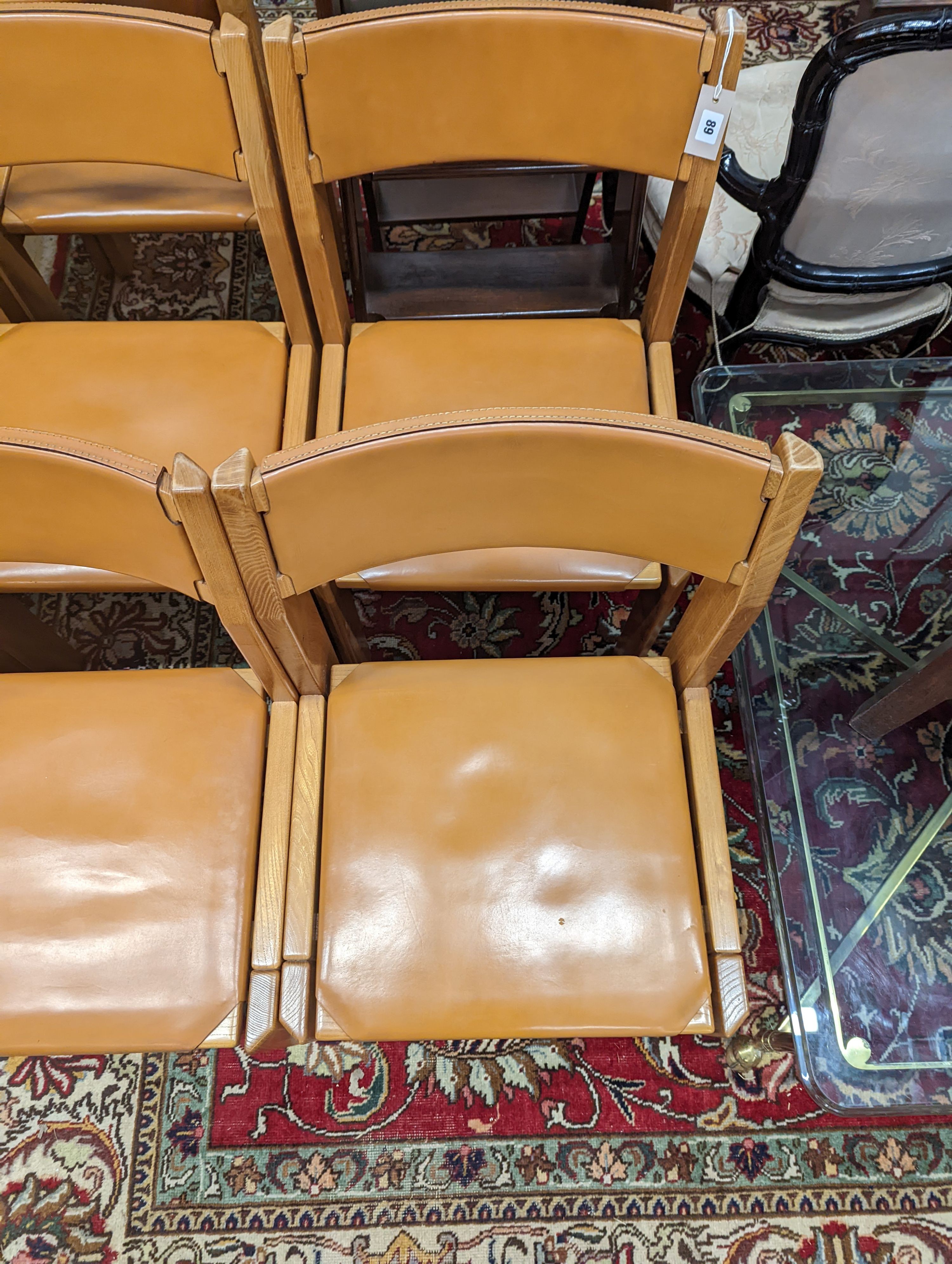 A set of eight mid century design walnut and tan leather dining chairs, width 48cm, depth 44cm, height 84cm